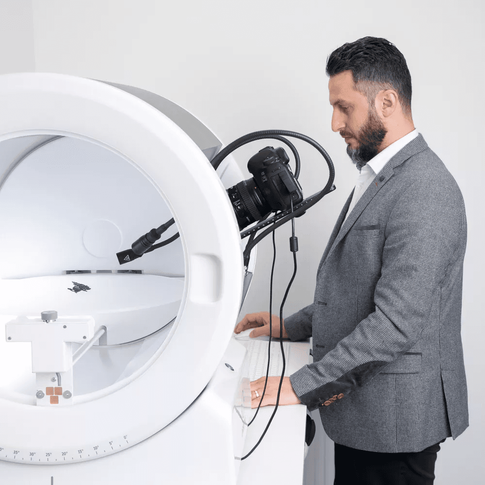 Hombre con traje operando un dispositivo de fotografía Orbitvu