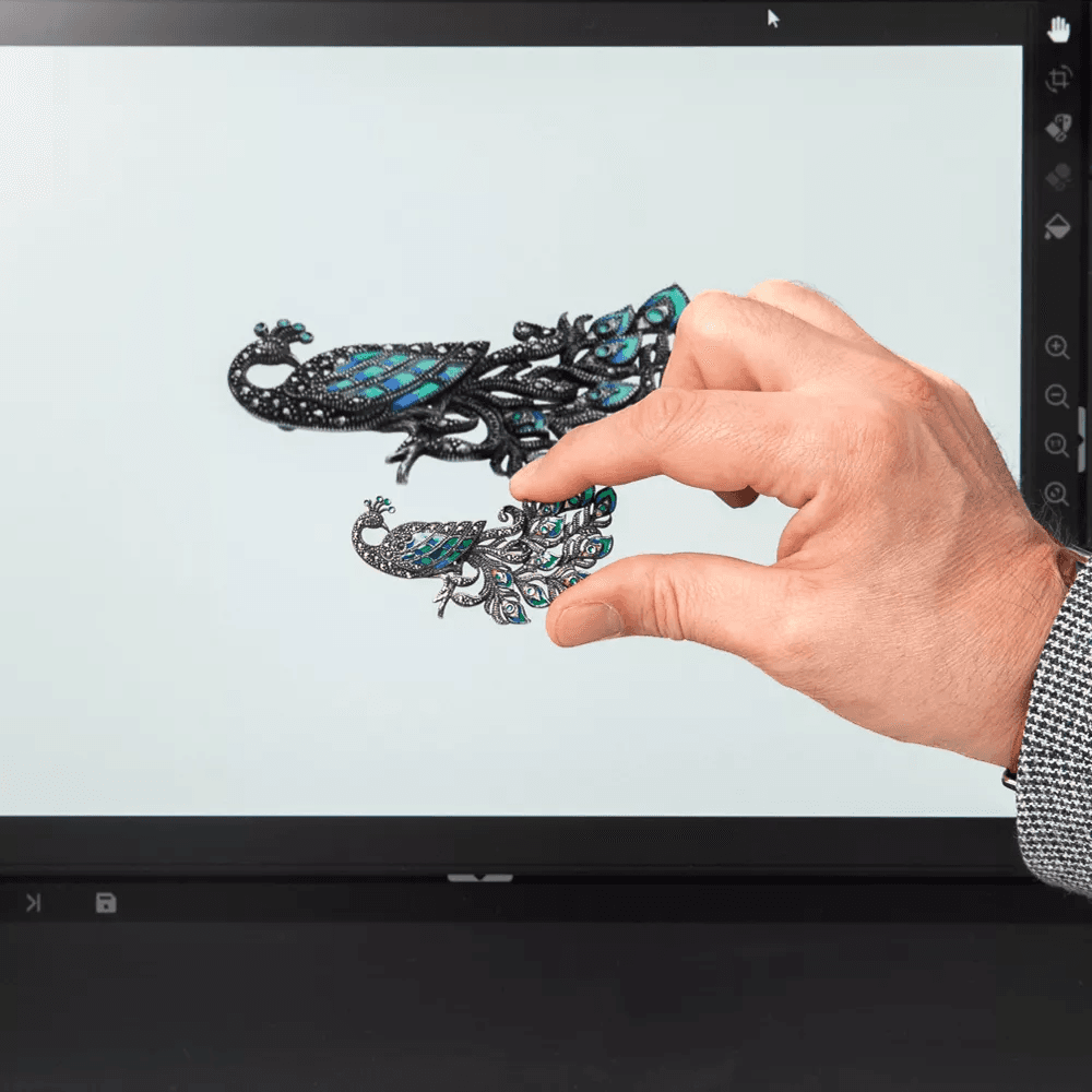Una mano sostiene una joya frente a una pantalla con el software Orbitvu.